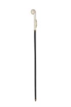 *A WALKING CANE, the ivory 'fist handle' top, with elaborately carved coat of arms,
