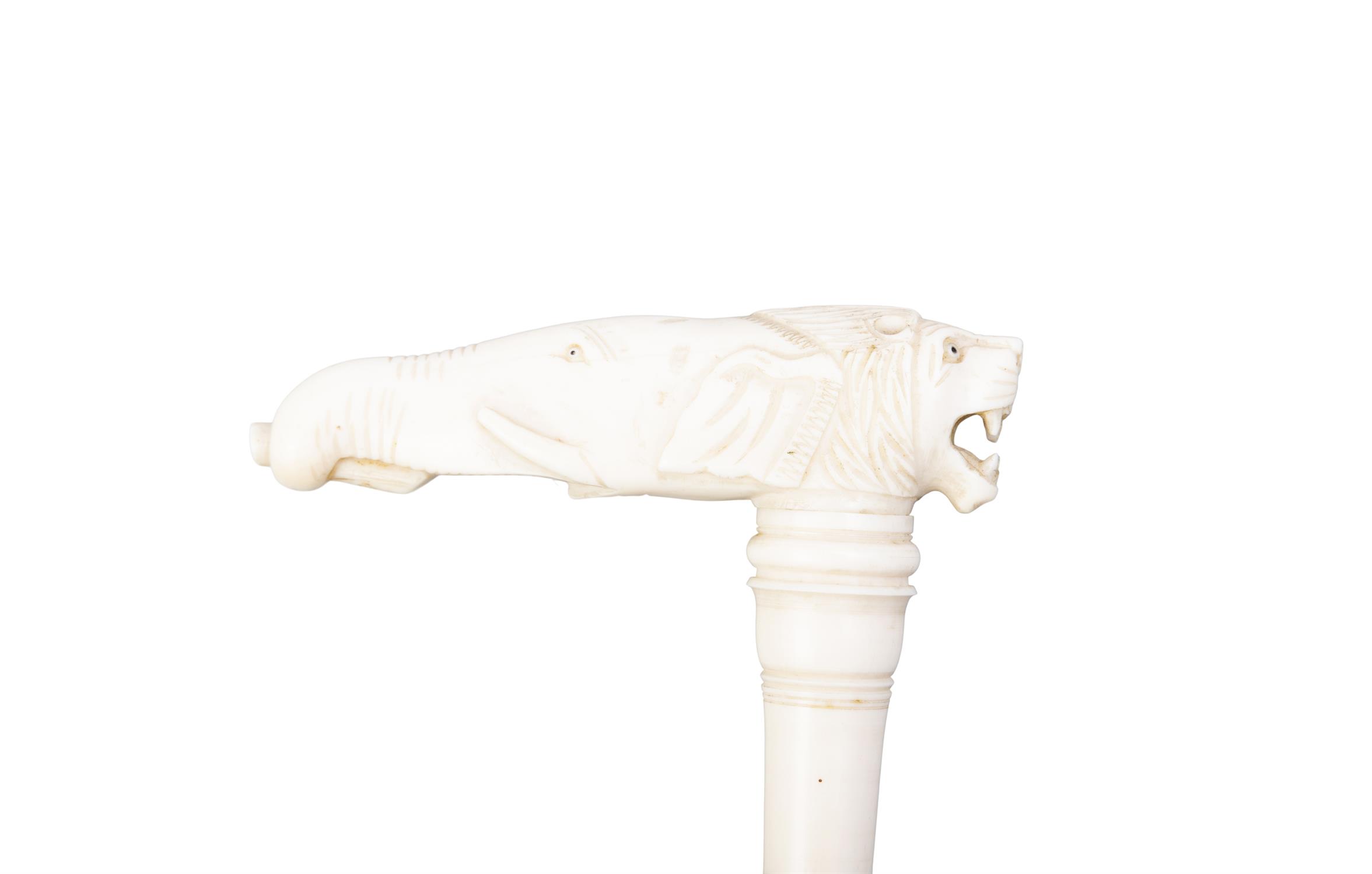 *A WALKING CANE, with a carved bone top formed as a lion and elephant head, the cane simulating - Image 2 of 2