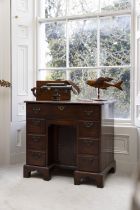 A GEORGE III MAHOGANY COMPACT KNEEHOLE DESK the rectangular top with moulded rim above a fall