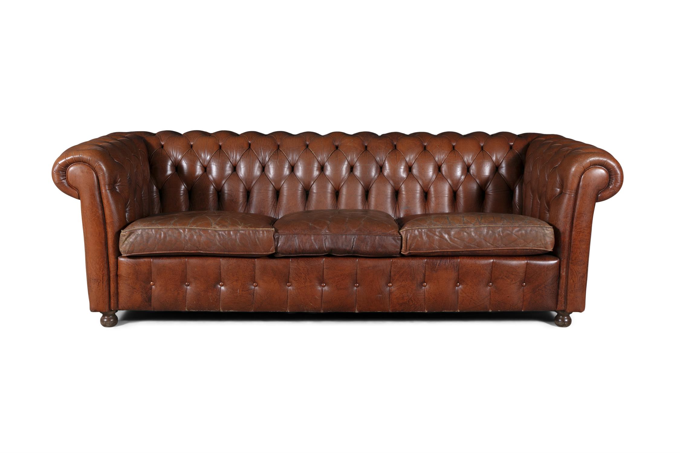 A CHESTERFIELD BUTTON BACK THREE SEATER SOFA, upholstered in brown leather with scroll-end