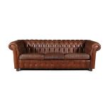 A CHESTERFIELD BUTTON BACK THREE SEATER SOFA, upholstered in brown leather with scroll-end