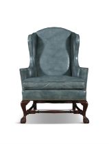AN UPHOLSTERERED MAHOGANY FRAMED WINGBACK ARMCHAIR C.1920 covered In teal leather,