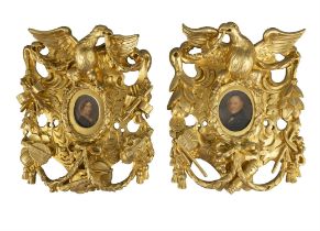 TWO GILTWOOD AND GESSO PIERCED CARVED FRAMES, each with central oval picture opening in the
