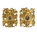 TWO GILTWOOD AND GESSO PIERCED CARVED FRAMES, each with central oval picture opening in the