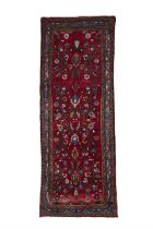AN IRANIAN RED GROUND WOOL RUNNER, 275 x 105cm the central field decorated with floral pattern