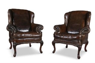 A PAIR OF BROWN LEATHER WINGBACK ARMCHAIRS, early 20th century examples with brass studding and