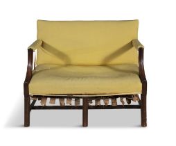 A GEORGE III MAHOGANY FRAMED TWO-SEATER SETTEE, C.1800 with reeded arm supports and tapering