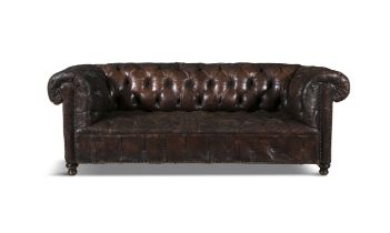 A BUTTONBACK BROWN LEATHER CHESTERFIELD SOFA of traditional design with out-scrolling arms and