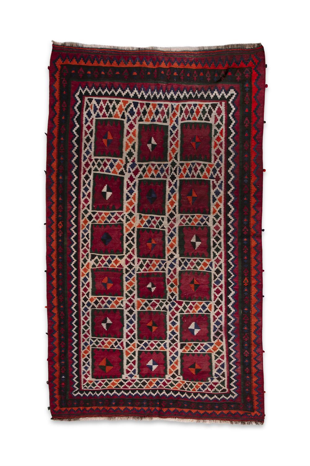 AN IRANIAN RED GROUND WOOL RUG, CA 1940s, 288 x 168cm the central field woven with three rows of