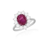 A RUBY AND DIAMOND CLUSTER RING The oval-shaped ruby within a brilliant-cut diamond surround,