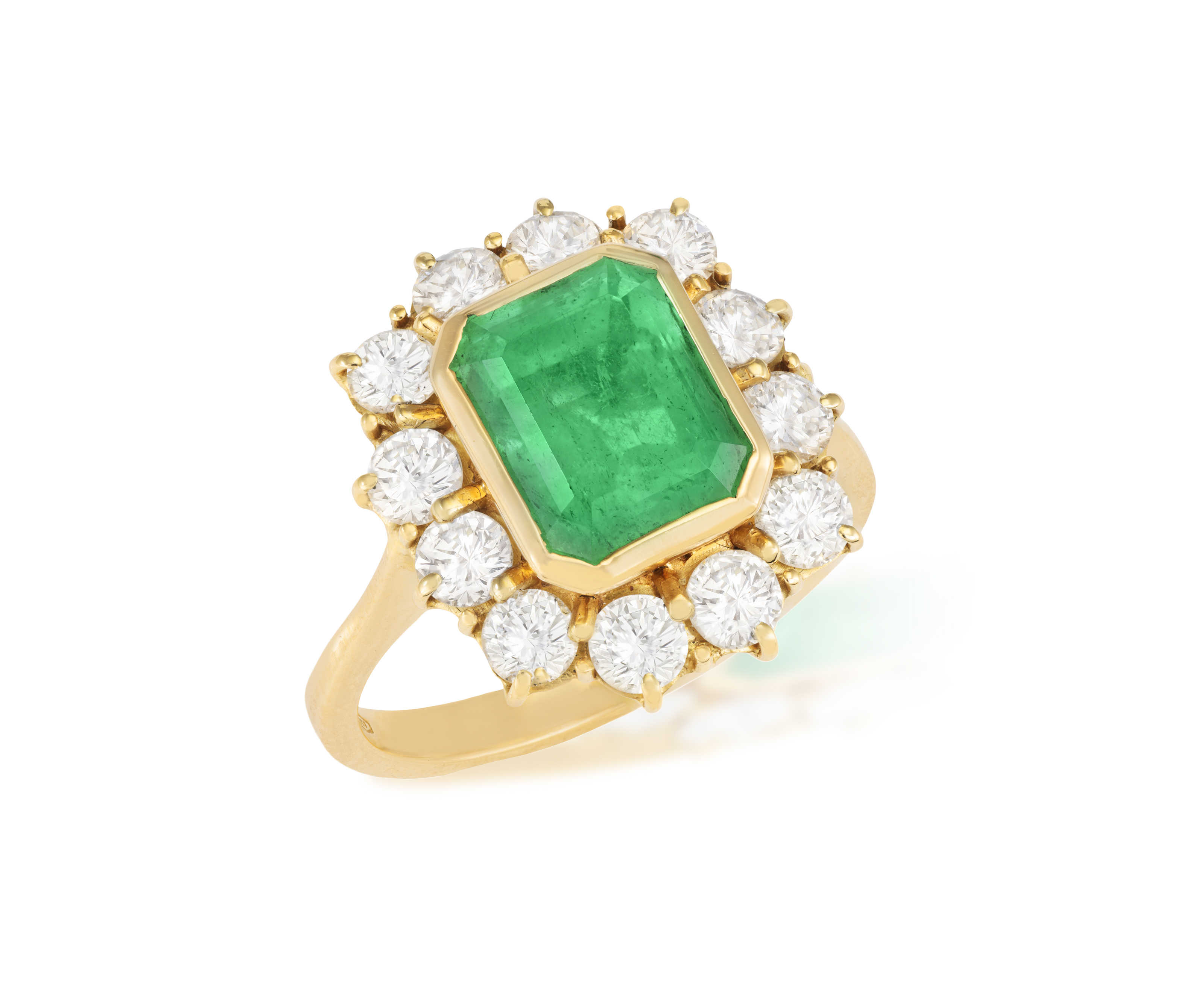 AN EMERALD AND DIAMOND CLUSTER RING The rectangular-cut emerald weighing approximately 2.80cts