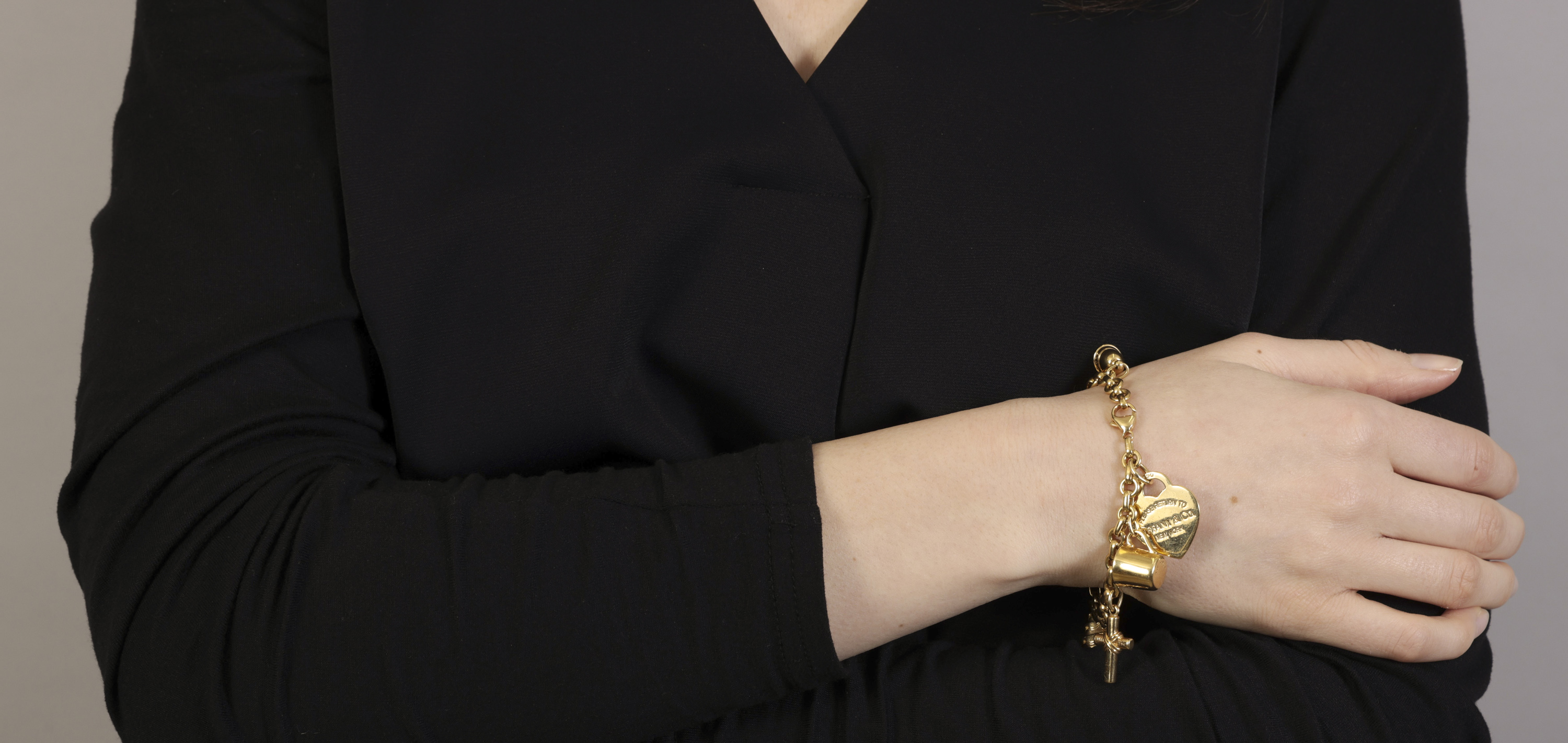 A GOLD AND DIAMOND CHARM BRACELET, BY TIFFANY & CO. The cable-link chain suspending six gold charms, - Image 3 of 4