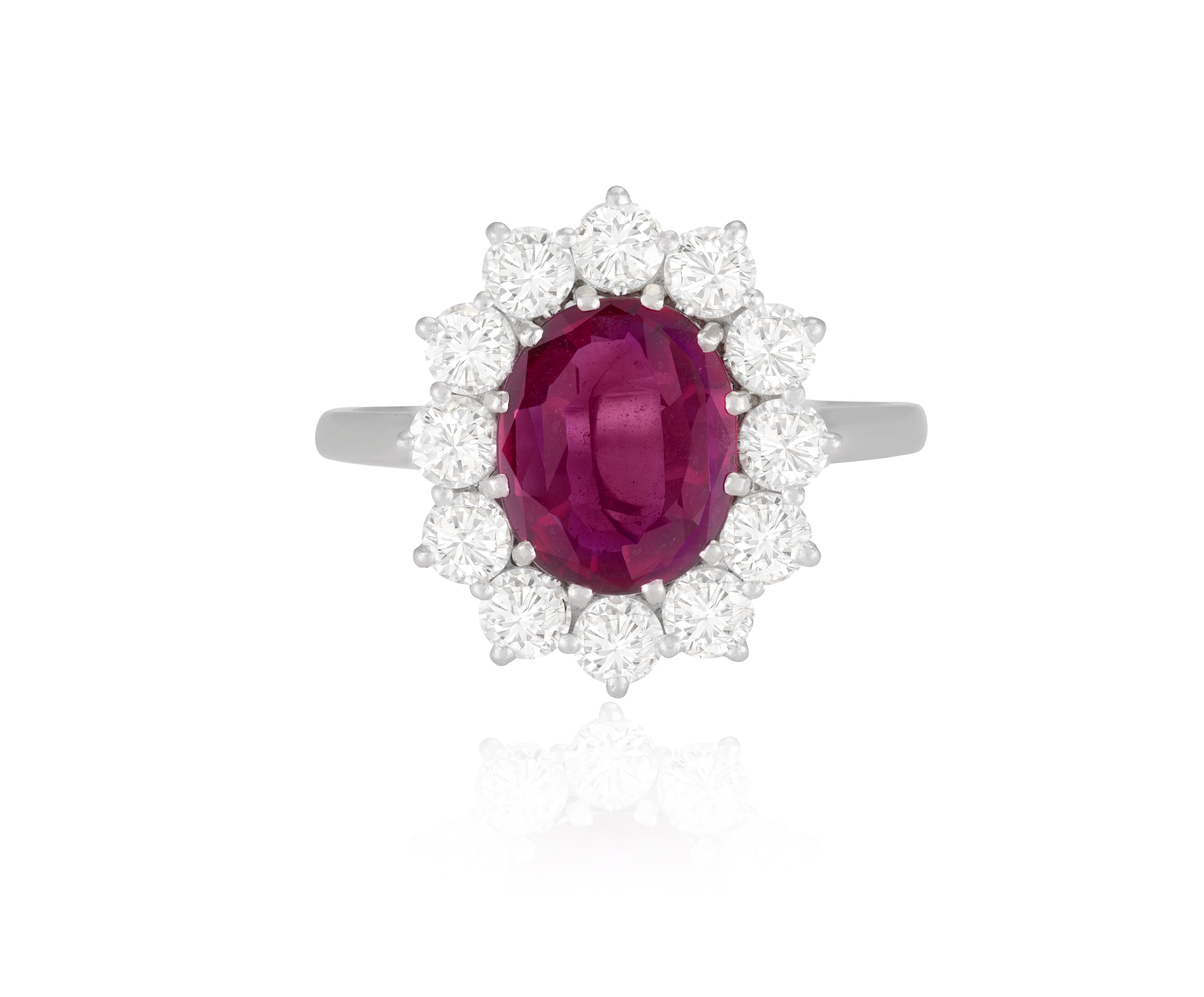 A RUBY AND DIAMOND CLUSTER RING The oval-shaped ruby within a brilliant-cut diamond surround, - Image 2 of 3