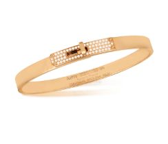AN 18K GOLD AND DIAMOND 'KELLY BRACELET' BY HERMÈS The polished oval gold bangle with 'Kelly' turn-
