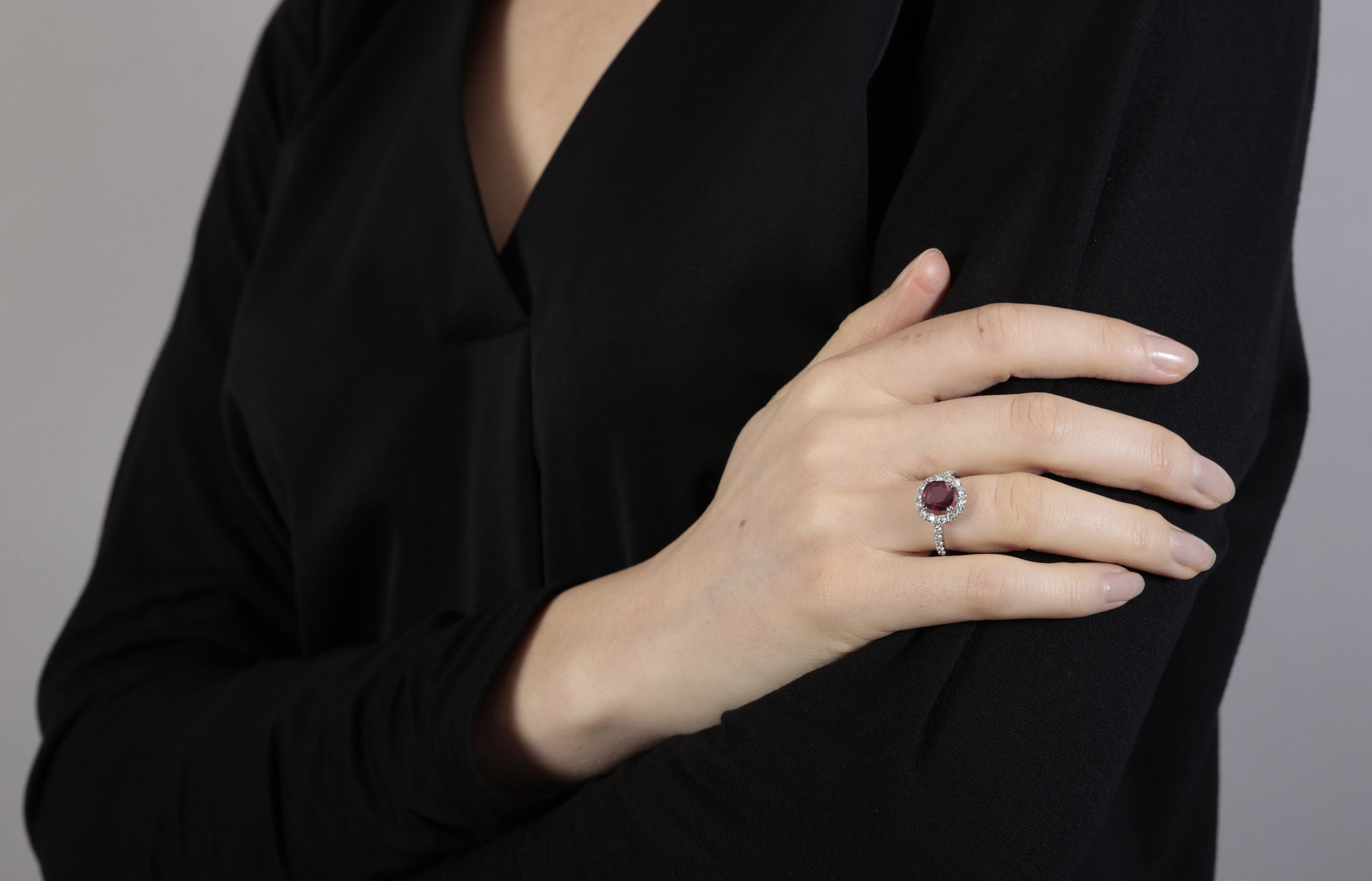 A RUBY AND DIAMOND CLUSTER RING The oval-shaped ruby within a brilliant-cut diamond surround, - Image 3 of 3