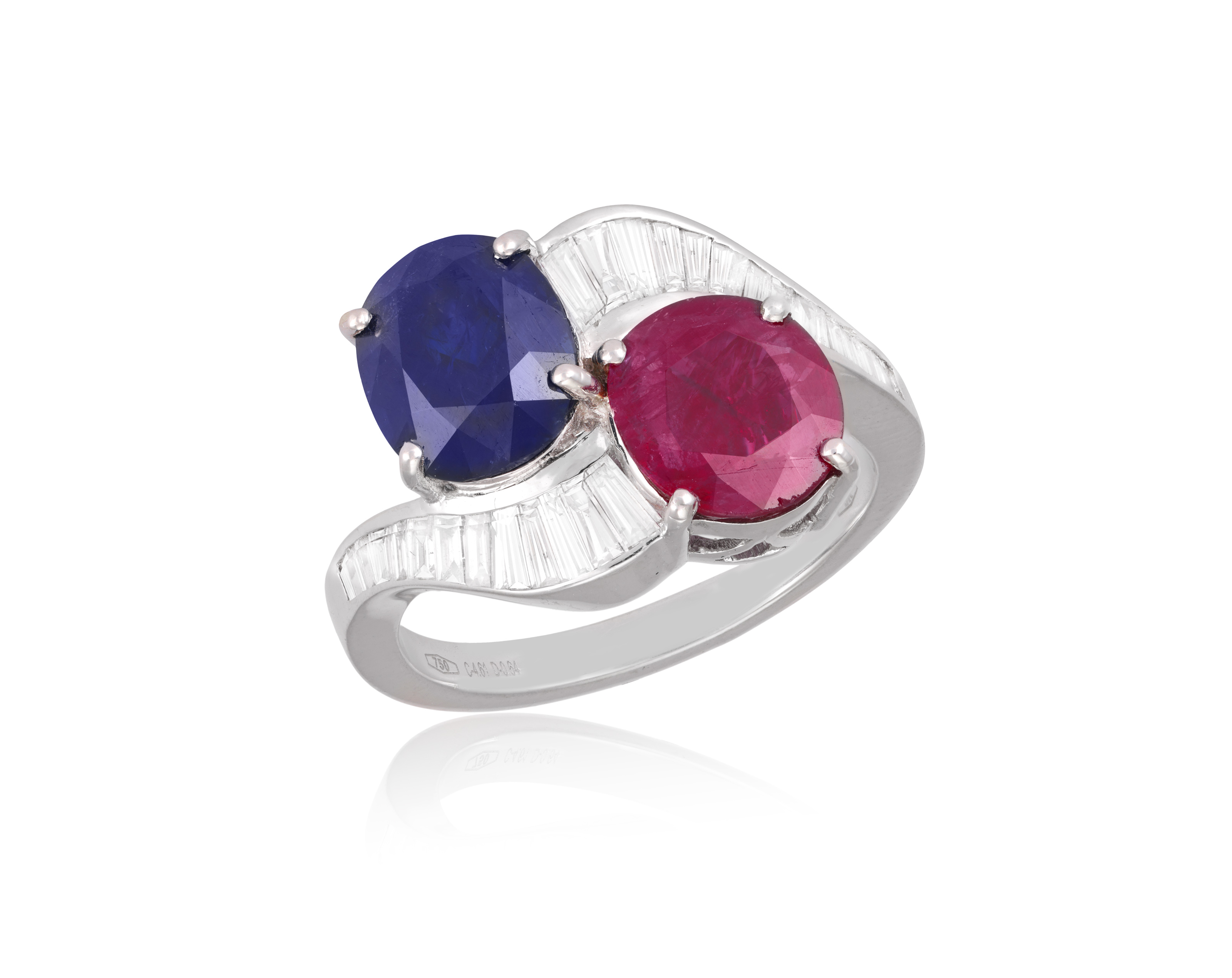 A RUBY, SAPPHIRE AND DIAMOND DRESS RING Of crossover design, set with an oval-shaped sapphire and