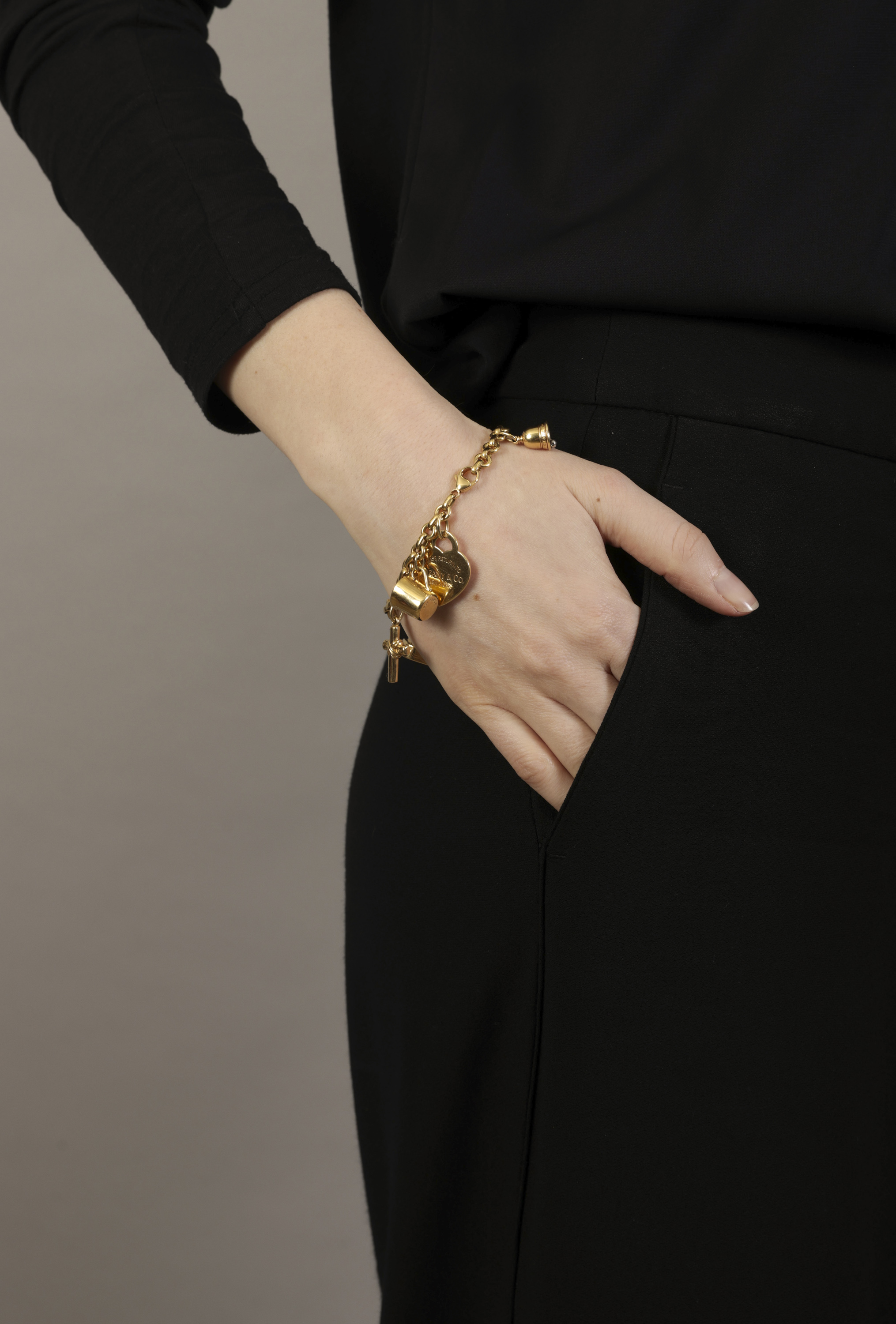 A GOLD AND DIAMOND CHARM BRACELET, BY TIFFANY & CO. The cable-link chain suspending six gold charms, - Image 4 of 4