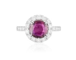 A RUBY AND DIAMOND DRESS RING The cushion-shaped ruby weighing approximately 1.56ct, within a