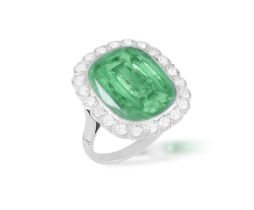 AN EMERALD AND DIAMOND CLUSTER RING The cushion-shaped emerald weighing approximately 6.50cts within