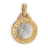 A GOLD ZODIAC PENDANT, BY BULGARI, CIRCA 1990 The circular concave pendant, the front side cast to