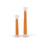 CANDLE STICKS A pair of orange and clear glass candle sticks of differing heights. Italy. 39.
