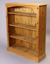 A pine standing open bookcase with three adjustable shelves, & on a plinth base, 95.5cm wide x 117.