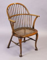 A Windsor comb-back tub-shaped chair with a woven-cane seat, & on cabriole legs & pad feet with