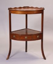 An early 19th century inlaid-mahogany bow-front two-tier corner washstand fitted with a centre