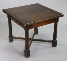 A mid-20th century oak drawer leaf dining table on four round tapered supports & square feet with