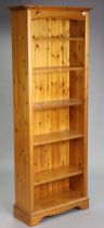 A pine tall standing open bookcase with five adjustable shelves, & on a shaped plinth base, 73cm