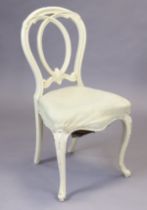 A Victorian white painted & carved wooden balloon-back salon chair with a padded seat, & on