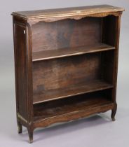 A French oak serpentine-front dwarf standing open bookcase with three adjustable shelves, & on short