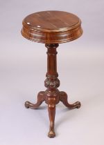 A 19th century mahogany vanity table with two hinged compartments to the circular top, & on a carved