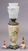 A Victorian peach glass oil table lamp with painted bird & floral decoration on a metal base, & with