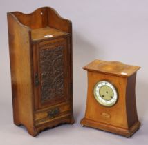 An early 20th century pipe-smoker’s cabinet with a fitted interior enclosed by a carved panel