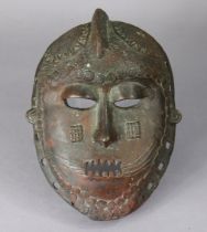 A West African bronze face mask, with all-over stylised decoration, 28.5cm x 21cm.