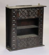 A 17th century and later oak hanging wall shelf with carved stylised decoration & two open