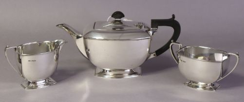 An Art Deco style silver three-piece tea service of rounded oblong form, each on flared rim foot;