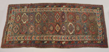 An antique Persian runner of madder ground with two central rows of medallions within