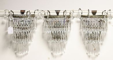 A set of three late Victorian gilt-metal mirror-back wall sconces hung with cascading prism drops,