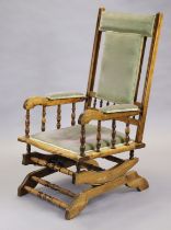 A late 19th/early 20th century American walnut rocking chair with padded seat, back and arms