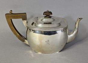 A George V silver teapot of rounded oblong form, with gadrooned rim & engraved family crest;