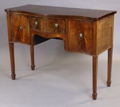 A Georgian mahogany sideboard of serpentine shape, with crossbanded top, central frieze drawer and