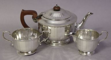 A George V silver three-piece tea service of round form with facetted sides; Birmingham 1931, by