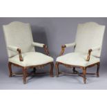 A pair of 18th century French walnut armchairs, each with padded seat, back & open arms, upholstered