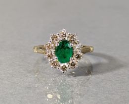 AN EMERALD & DIAMOND RING, the oval-cut emerald weighing approx. 0.85 carat, set within a border