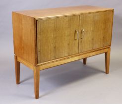 A Gordon Russell of Broadway small teak sideboard, enclosed by a pair of panel doors, & on square