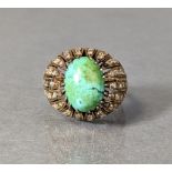 A cocktail ring set large oval-cut turquoise within a wide open border set numerous rose diamonds,