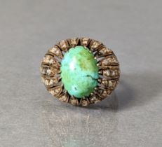 A cocktail ring set large oval-cut turquoise within a wide open border set numerous rose diamonds,