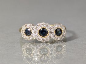 A sapphire & diamond ring, set three round-cut sapphires within circular borders of brilliant-cut